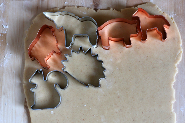 animal cookie cutters cutting shapes out of the rolled out cookie dough