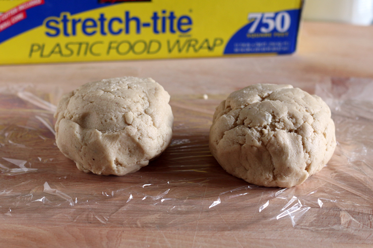 two cookie dough balls about to be wrapped in plastic wrap to chill