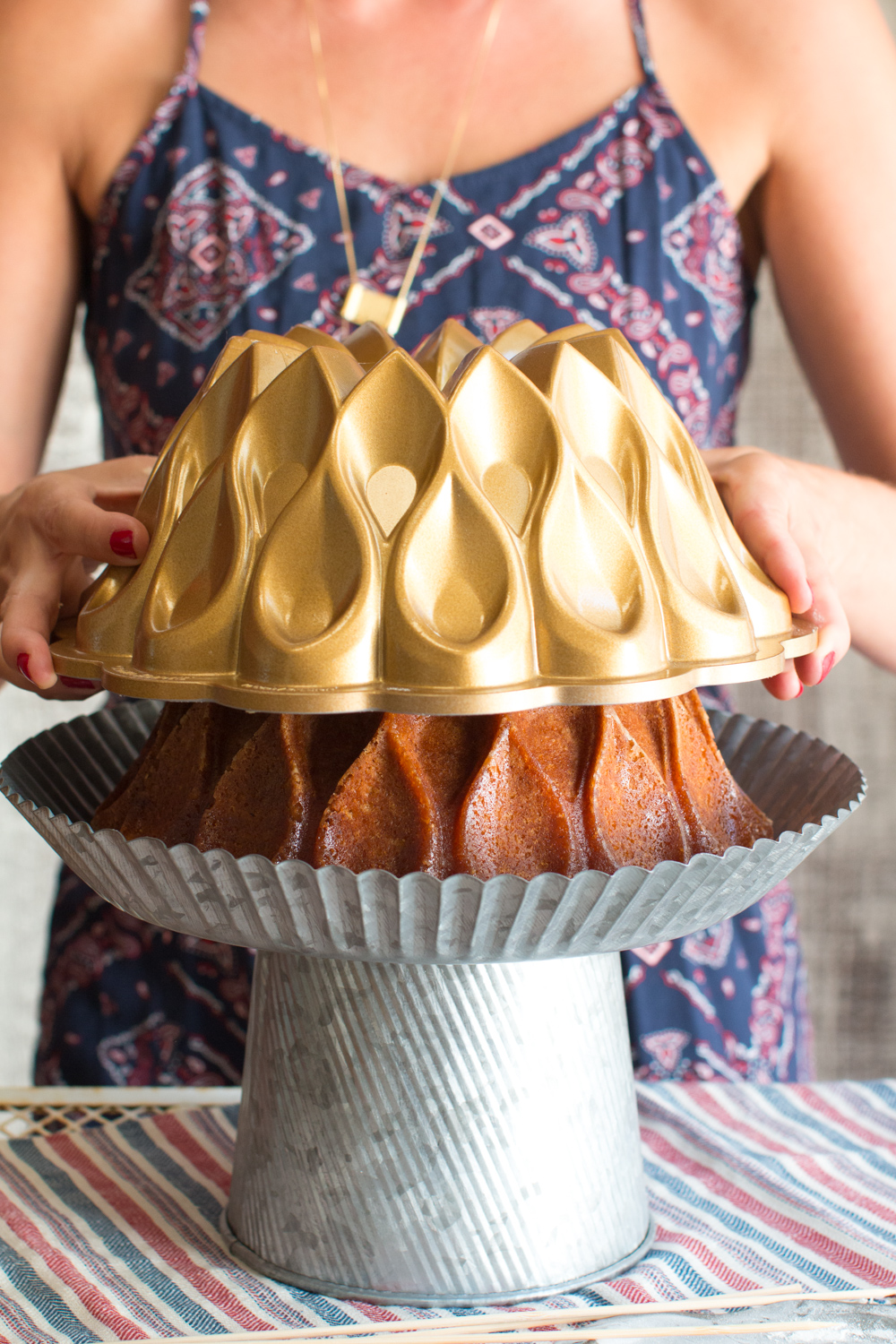 turning out brown butter bourbon bundt cake onto a cake stand