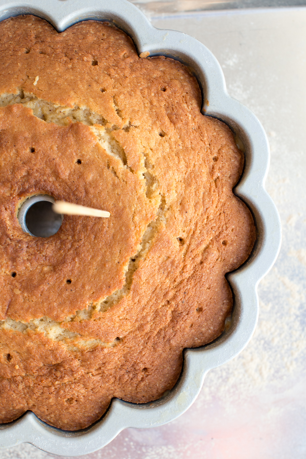 poking holes in a brown butter bourbon bundt cake baked fresh from the oven