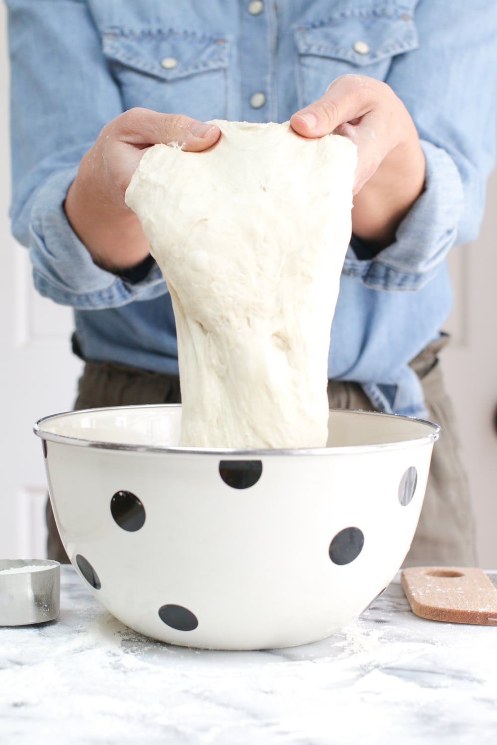 holding the 72 hour pizza dough after fermentation to show its elasticity