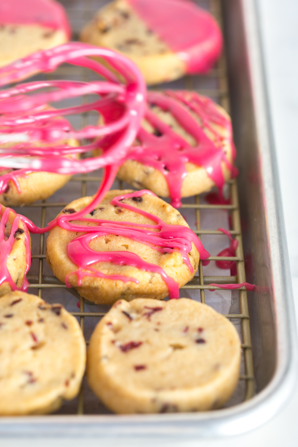 Drizzling the Glazed Hibiscus Shortbread Cookies with glaze