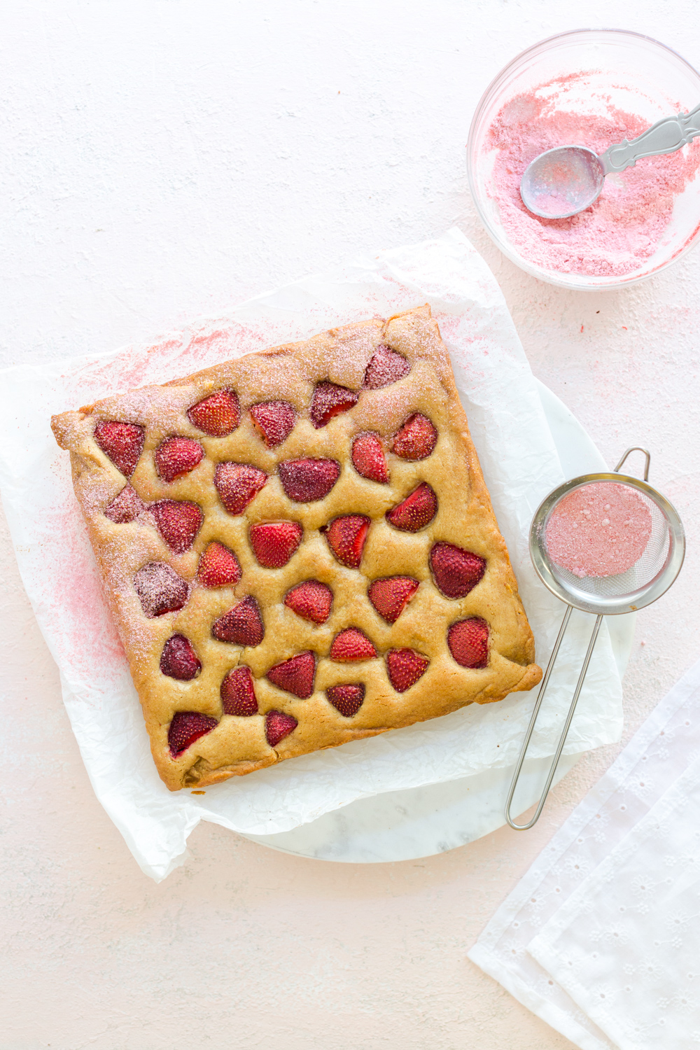 Sifting freeze dried strawberry powder over Strawberry Blondies