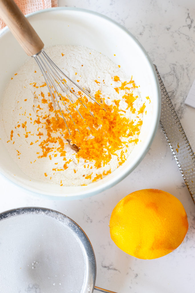 whisking orange zest into dry ingredients