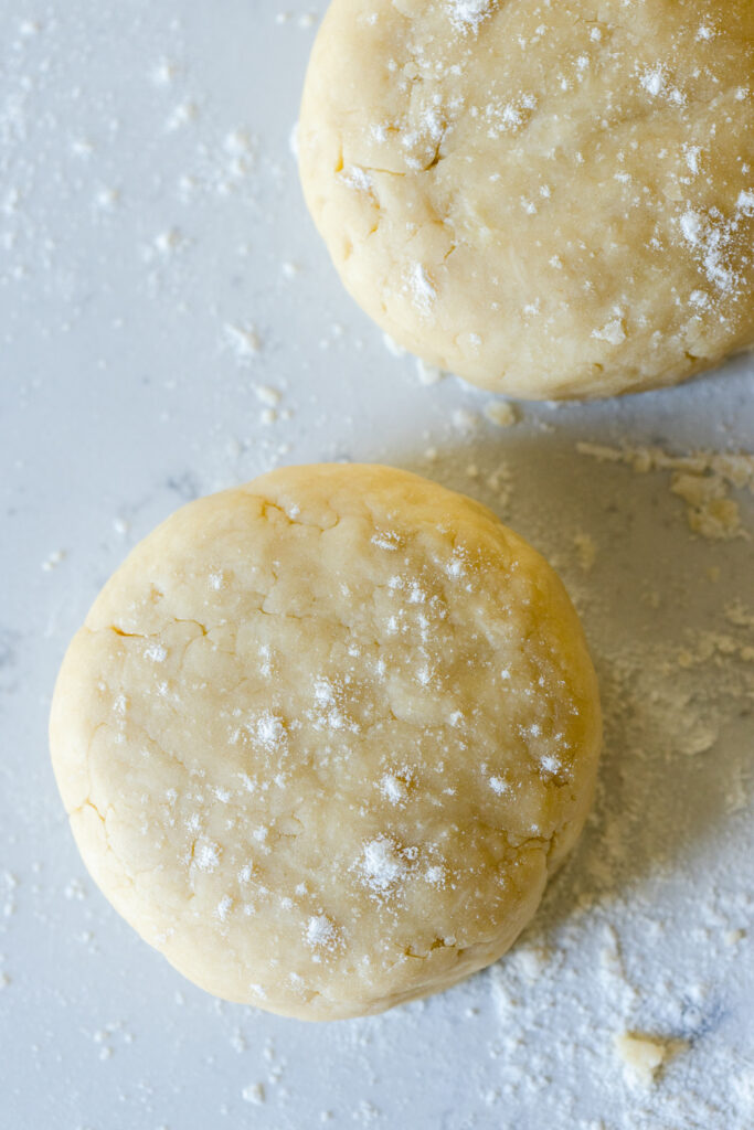 A close up of Basic All Butter Pie Dough disks with visible texture