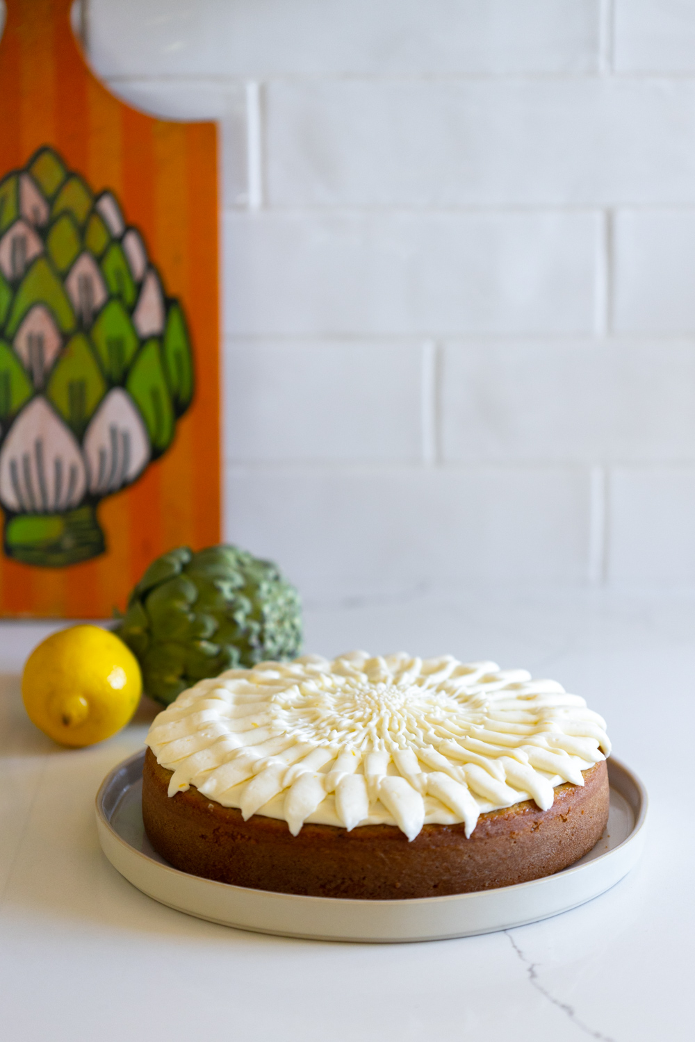 Artichoke Olive Oil Cake with Lemon Cream Cheese Frosting on counter