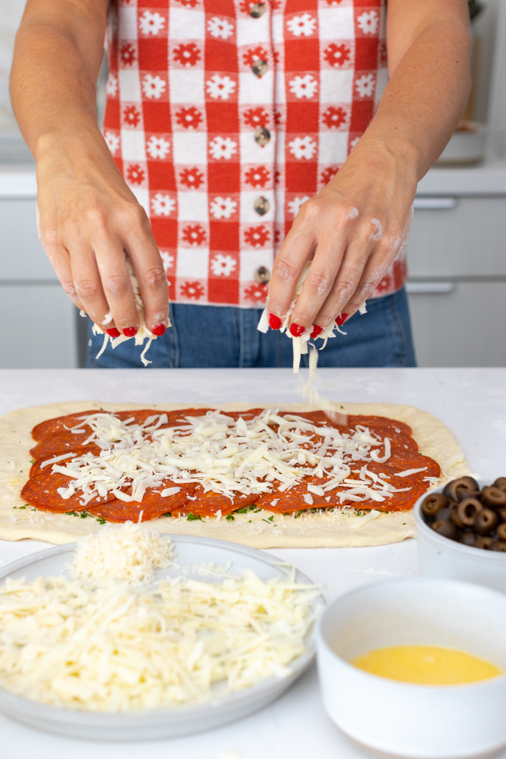 adding cheese to Stromboli