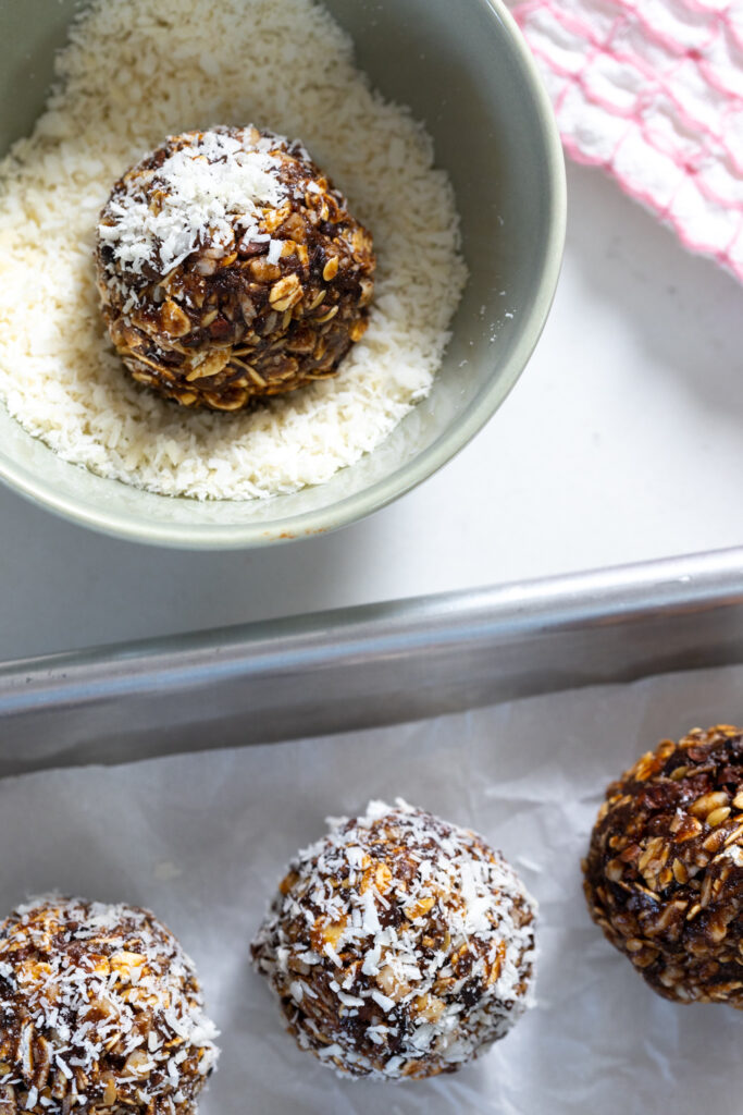 rolling energy balls in coconut