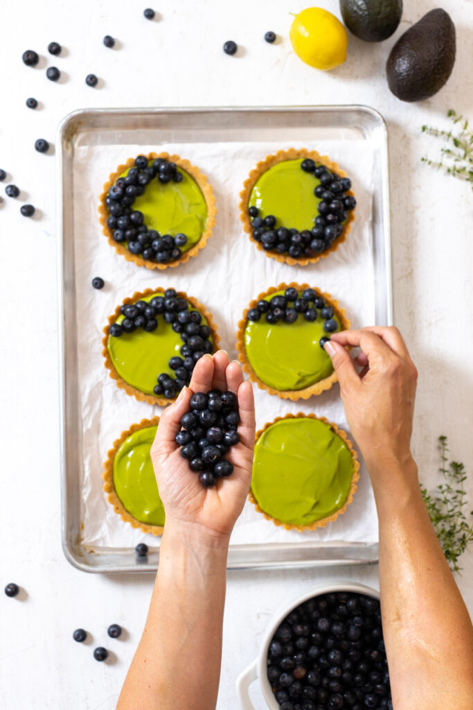 Topping Avocado Blueberry Tarts with Almond Crust with fresh blueberries