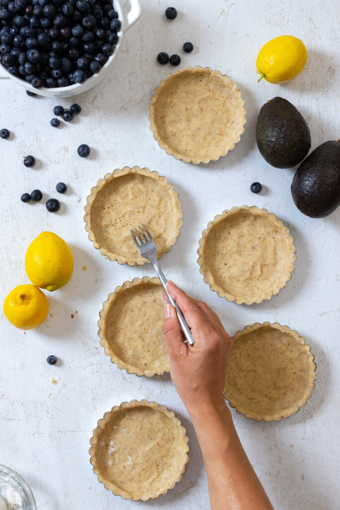 Pricking the almond shortbread tart shells with fork