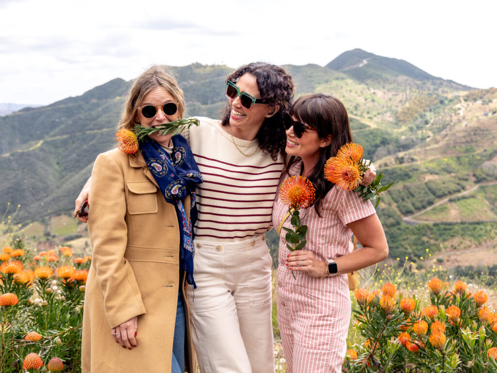 Kate of Hola Jalapeno, Aida of Salt and Wind and Becky Sue of Baking The Goods picking fresh Protea up on the hilltops of Resendiz Brothers flower farm