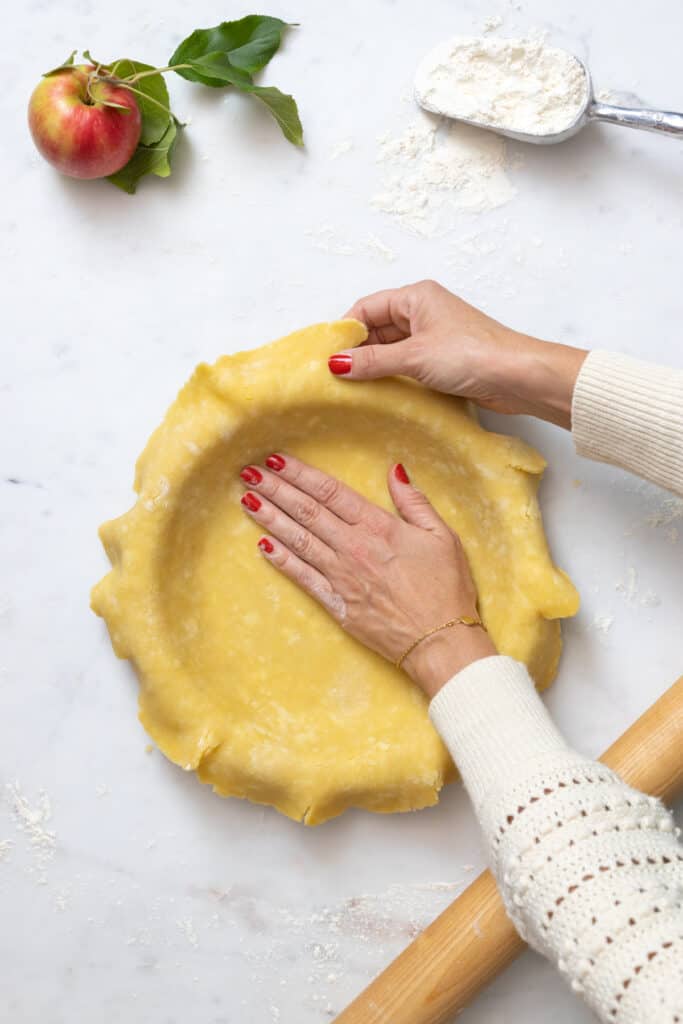 pressing dough into pie dish