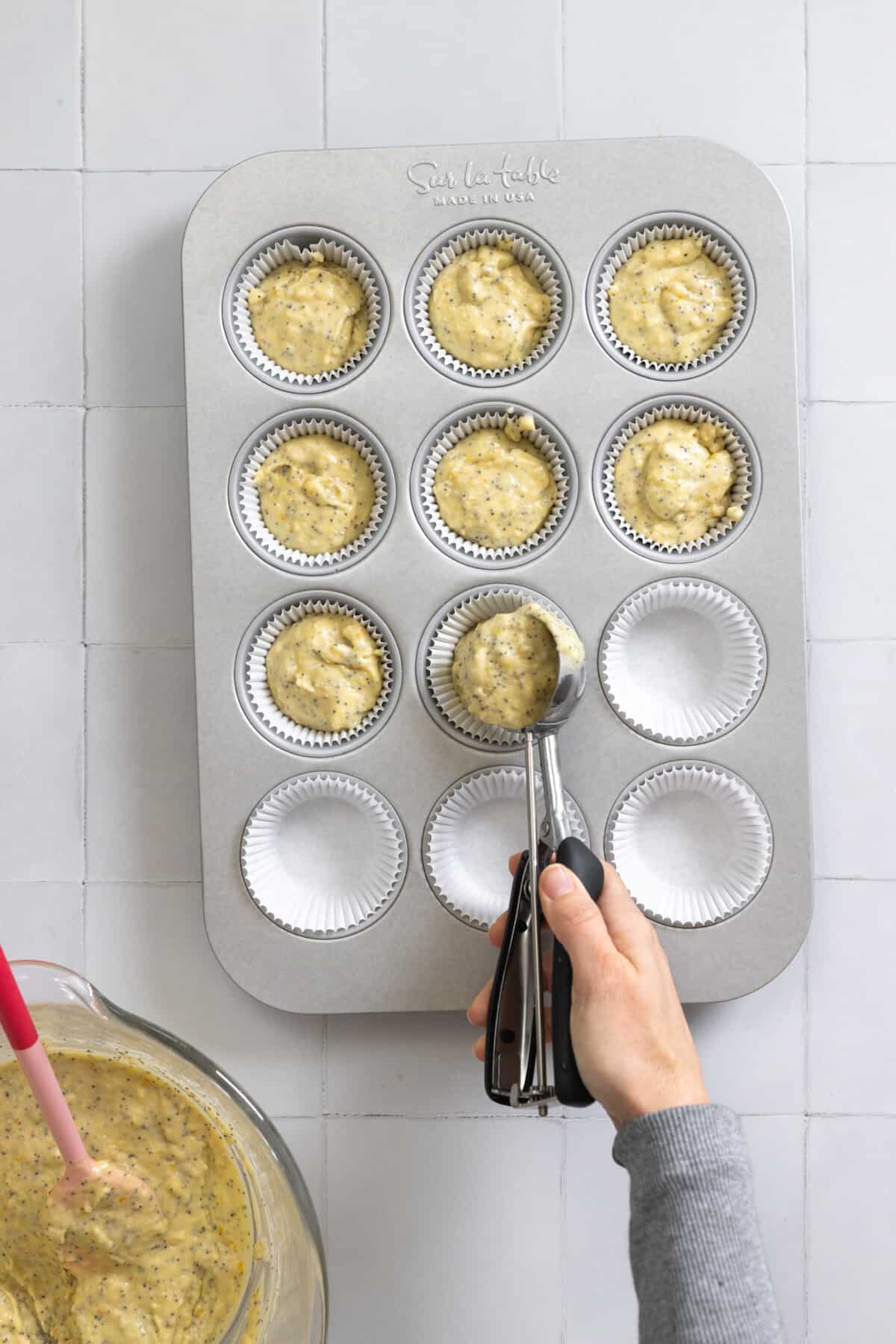filling muffin tin with batter