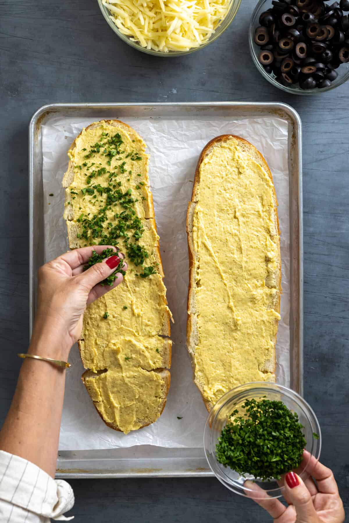 sprinkling herbs on garlic bread