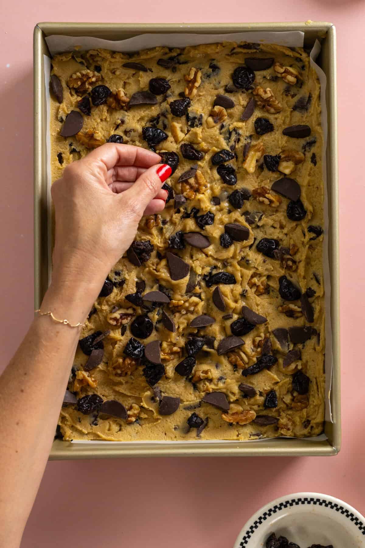 Topping Pressing tahini bar dough with mix-ins