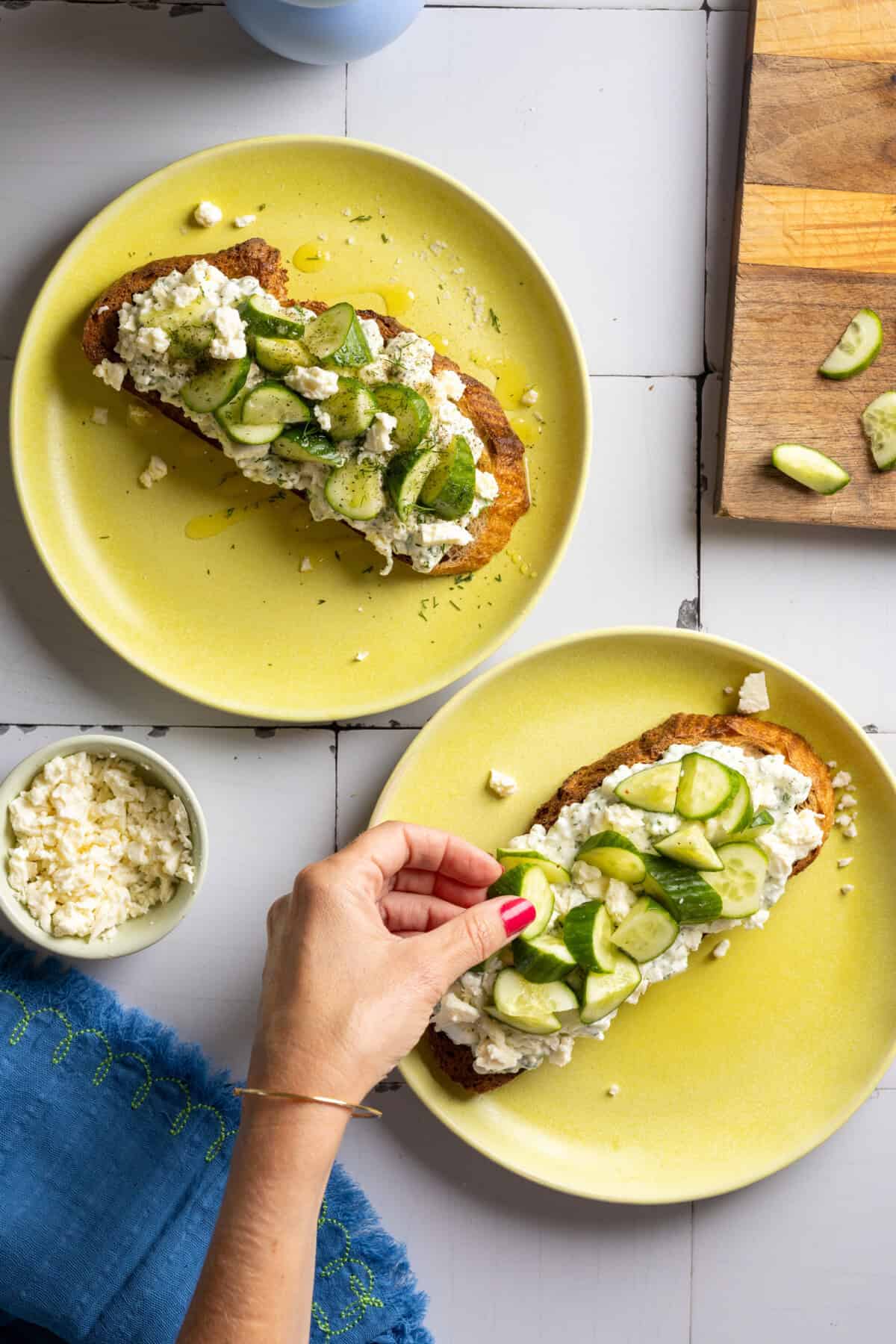 Adding cucumbers to Cottage Cheese Tzatziki Toasts