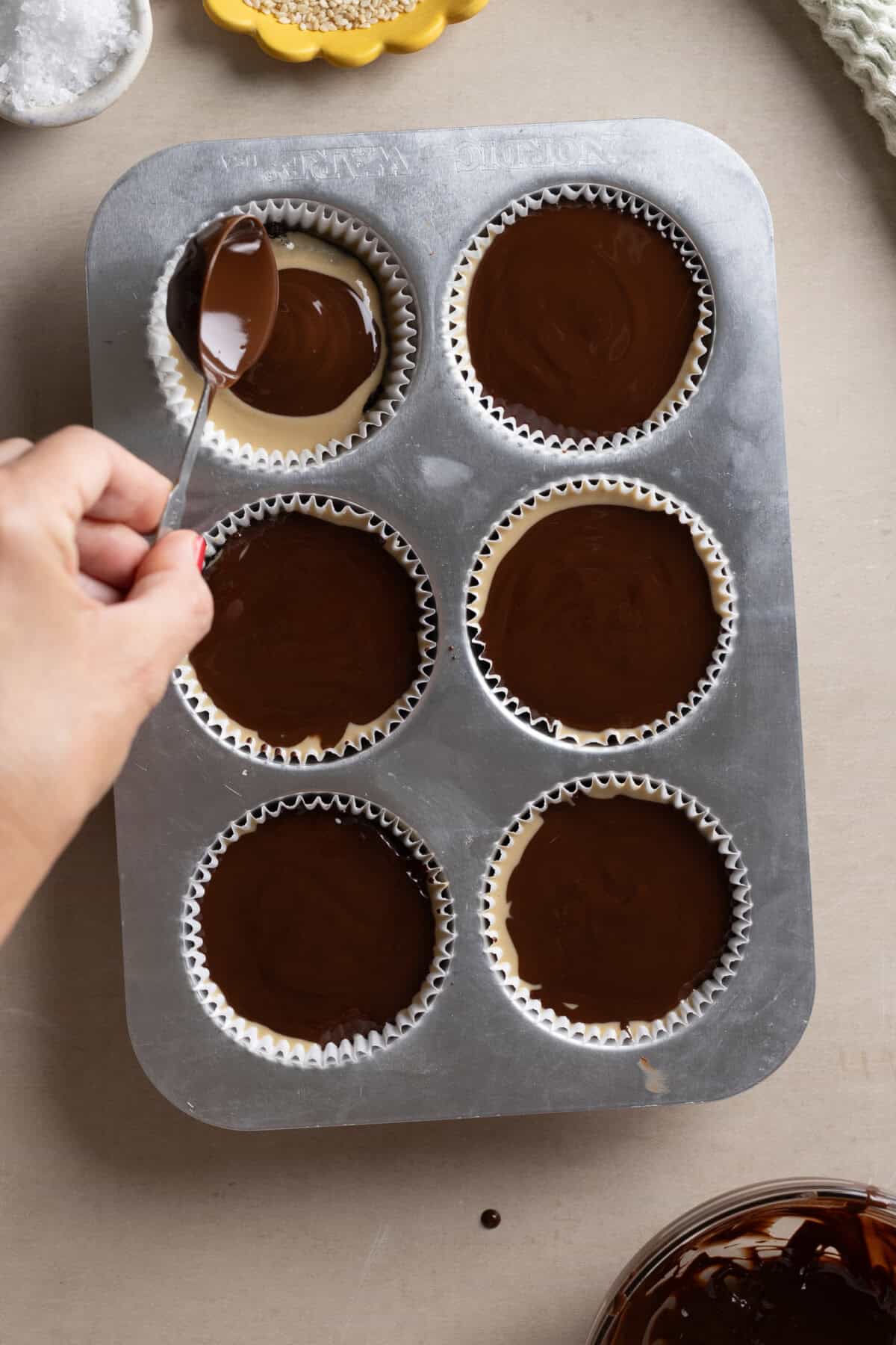 Adding melted chocolate layer to tahini to prune oat cups