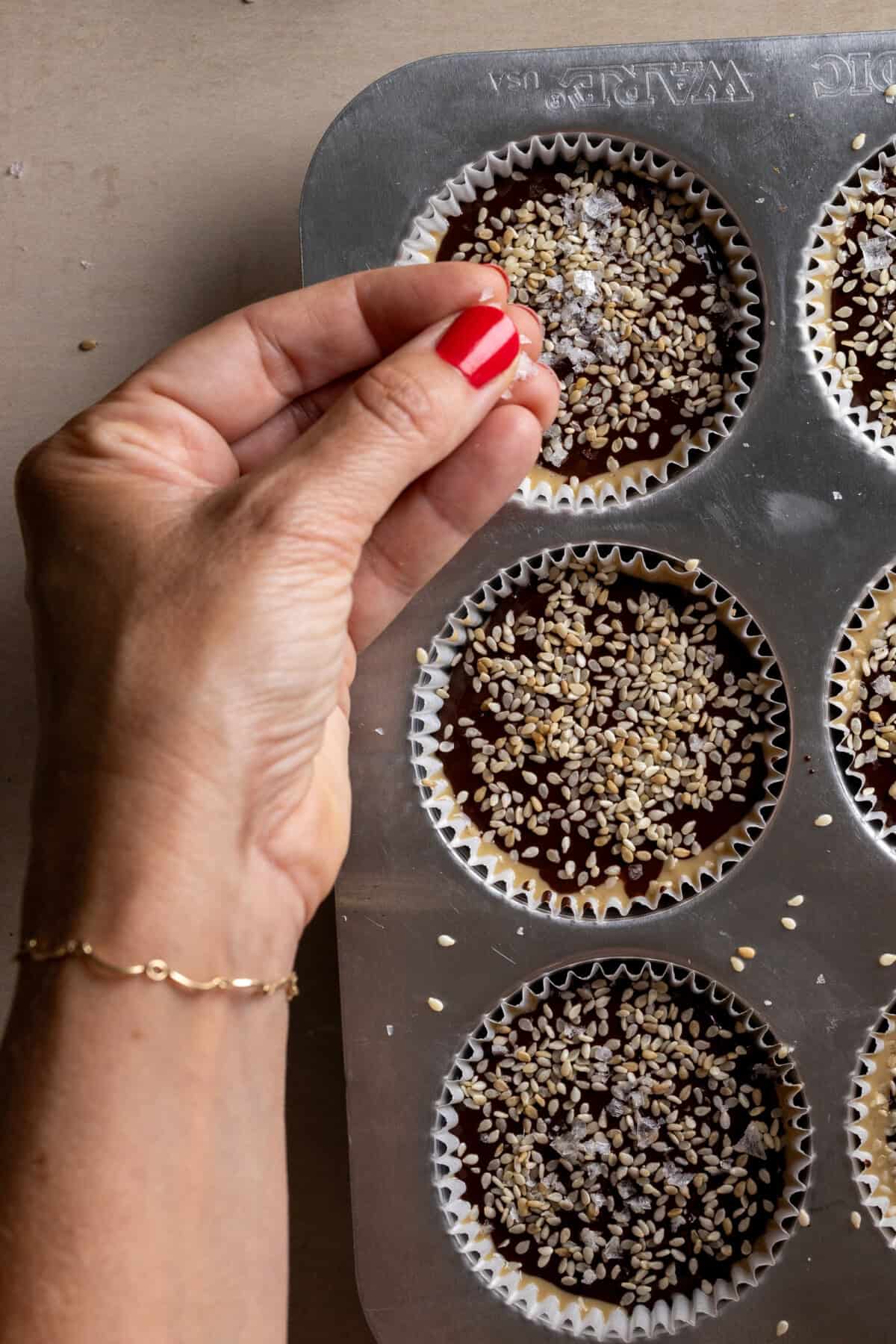 adding sea salt flakes to Chocolate Tahini Prune Oat Cups