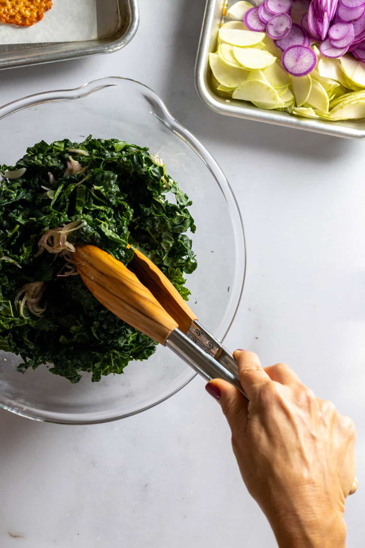 Tossing Kale Radish Kohlrabi Salad with dressing