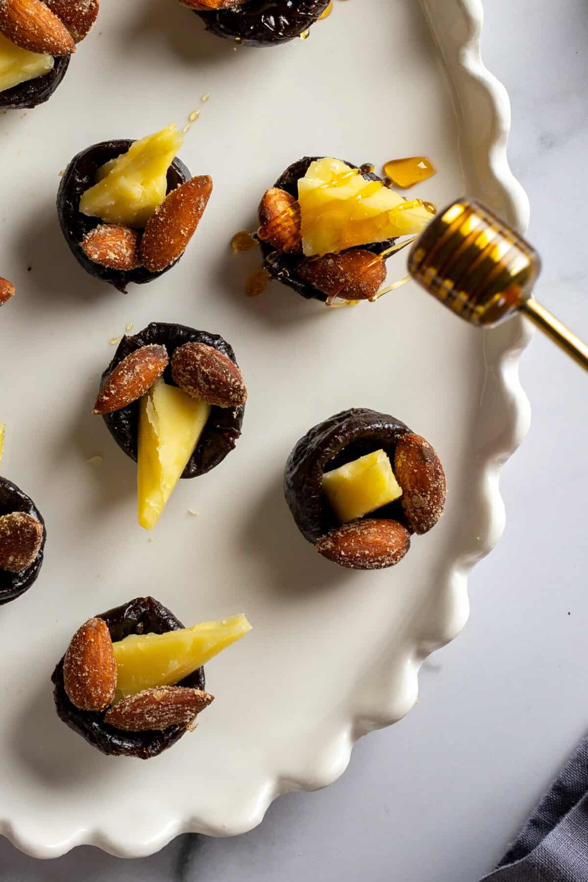 Drizzling Prune Cheddar Almond Bites with honey