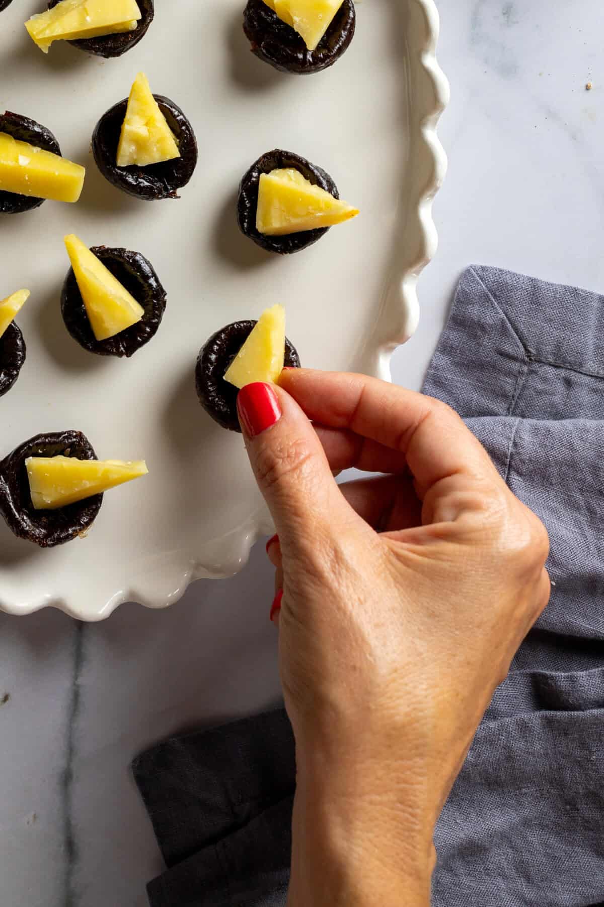 Adding Cheddar cheese wedges to prune cups